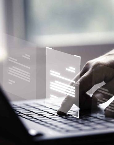 mano usando una computadora portatil con pantalla virtual y documento para aprobar en linea el concepto de gestion de erp y garantia de calidad sin papel scaled